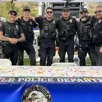 Officers standing together for a picture at the PD table during Rides and Reggae