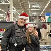 Officer O'Neil posing with a kiddo during the annual shop with a cop event